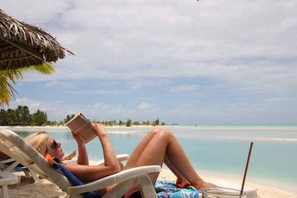 Läser bok på stranden